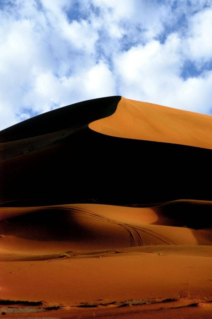 Sand dunes in the Sahara Desert under a blue sky during hiking in Morocco